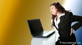 a person St Peters bending over a computer holding her back due to pain